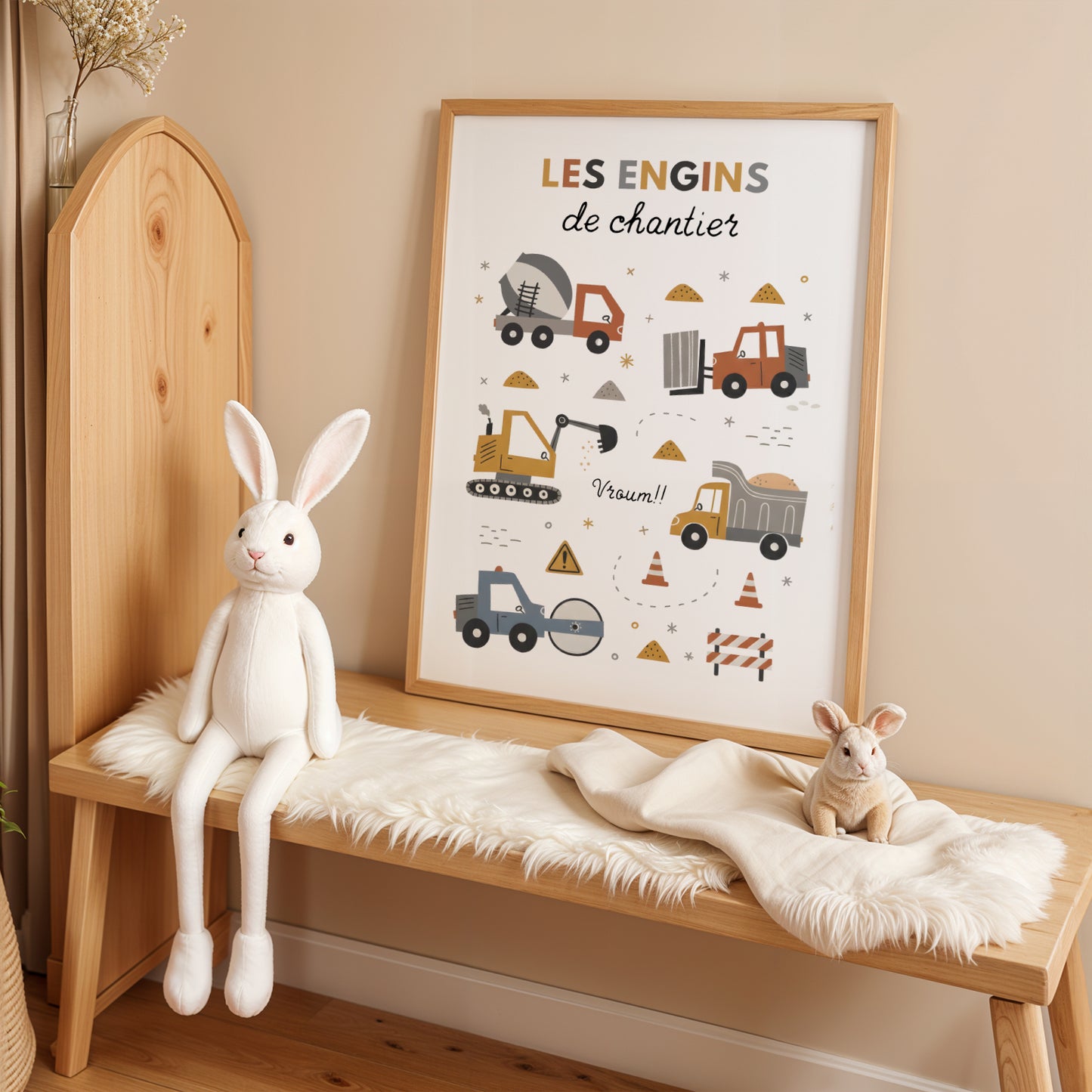 Ensemble de trois affiches sur le thème du chantier pour enfant, présentées dans des cadres en bois clair. L'affiche du milieu liste différents véhicules sous le titre 'Les engins de chantier'. Les deux affiches latérales montrent une grue et une pelleteuse. Style d'illustration minimaliste aux couleurs ocre, gris et bleu dans une chambre d'enfant lumineuse et épurée