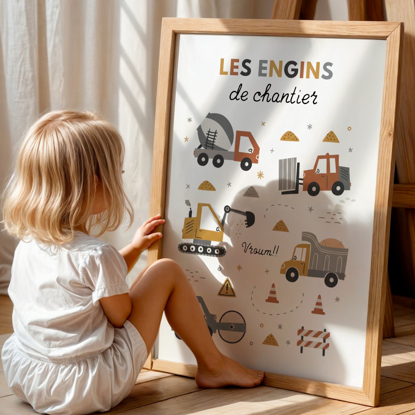 Ensemble de trois affiches sur le thème du chantier pour enfant, présentées dans des cadres en bois clair. L'affiche du milieu liste différents véhicules sous le titre 'Les engins de chantier'. Les deux affiches latérales montrent une grue et une pelleteuse. Style d'illustration minimaliste aux couleurs ocre, gris et bleu dans une chambre d'enfant lumineuse et épurée