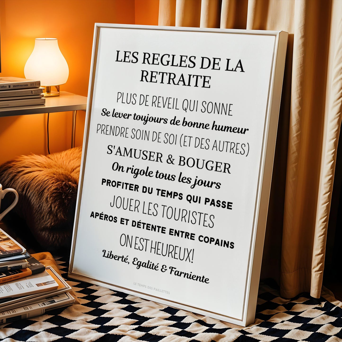 The "Affiche cadeau départ à la retraite - poster retraiter personnalisé par Le Temps des Paillettes" affiche lists joyful retirement rules like enjoying each day and relaxing. This charming décoration retraite is displayed resting near a lamp and curtains.