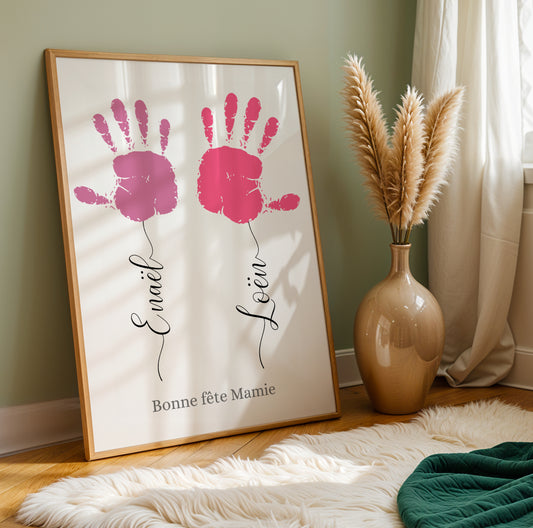 Affiche Mamie Personnalisée with two pink children's handprints and handwritten names on white background for Fête des.