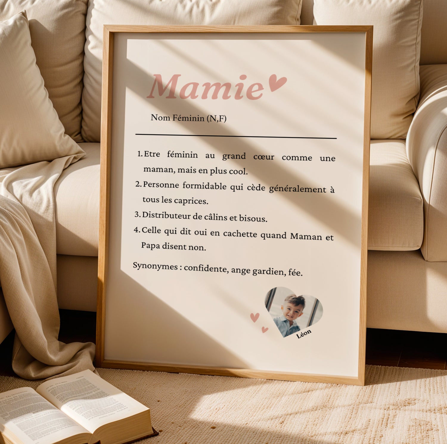 Affiche Mamie Personnalisée with custom text and photo in light pink font, framed on floor for Fête des Grands-Mères.