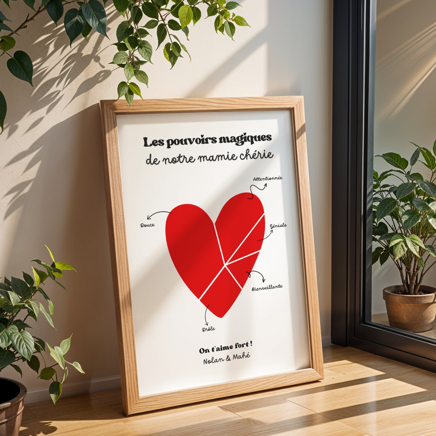Affiche Mamie Personnalisée with red heart and magical powers text, framed on wooden tabletop for Fête des Grands-Mères.